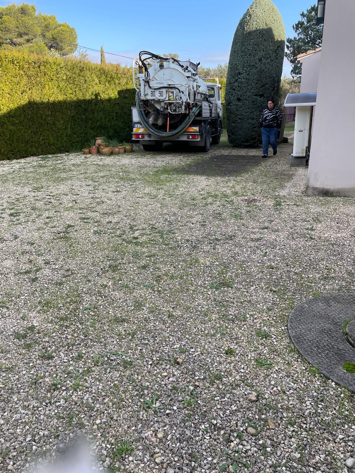 Camion hydrocureur positionné devant un logement pour un débouchage de canalisation